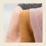 Baby muslin squares folded in soft pastel tones showing the double gauze texture