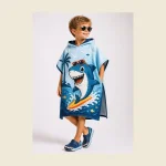 Child wearing a blue hooded kids beach poncho with a printed shark motif