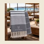 Private label peshtemal in navy and white stripe with a woven MONNEVA label and knotted fringe