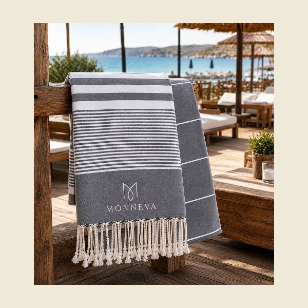 Private label peshtemal in navy and white stripe with a woven MONNEVA label and knotted fringe