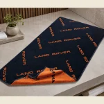 Promotional towel with an all-over branded logo print in navy and orange