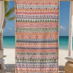 Multicolour patterned hammam beach towel with fringed ends hanging in a beach cabana above white sand